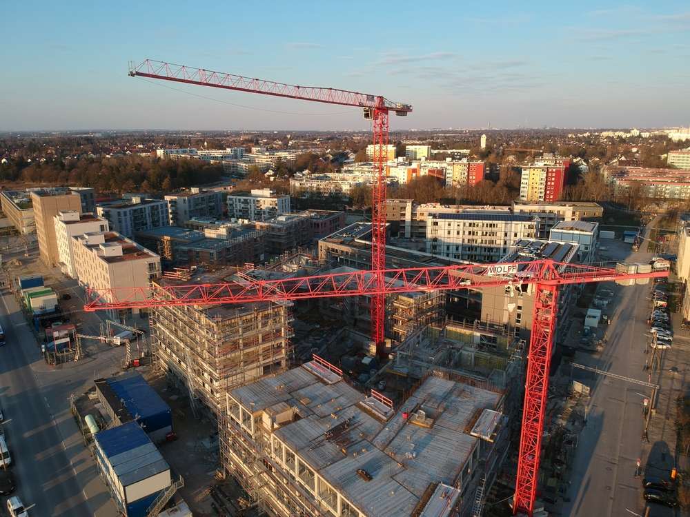 Luftaufnahme der Großbaustelle in Freiham mit mehreren Baukränen – zukunftsweisende Immobilien-Wertsteigerung in München 2030.