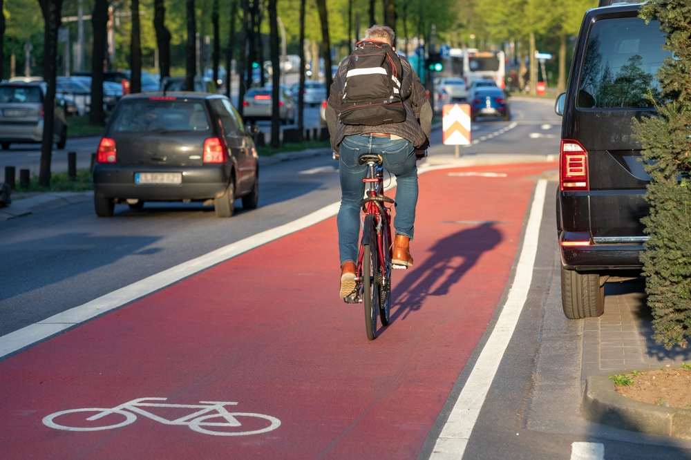 Radfahrer auf rotem Fahrradweg in München – nachhaltige Mobilität in modernen Wohnquartieren